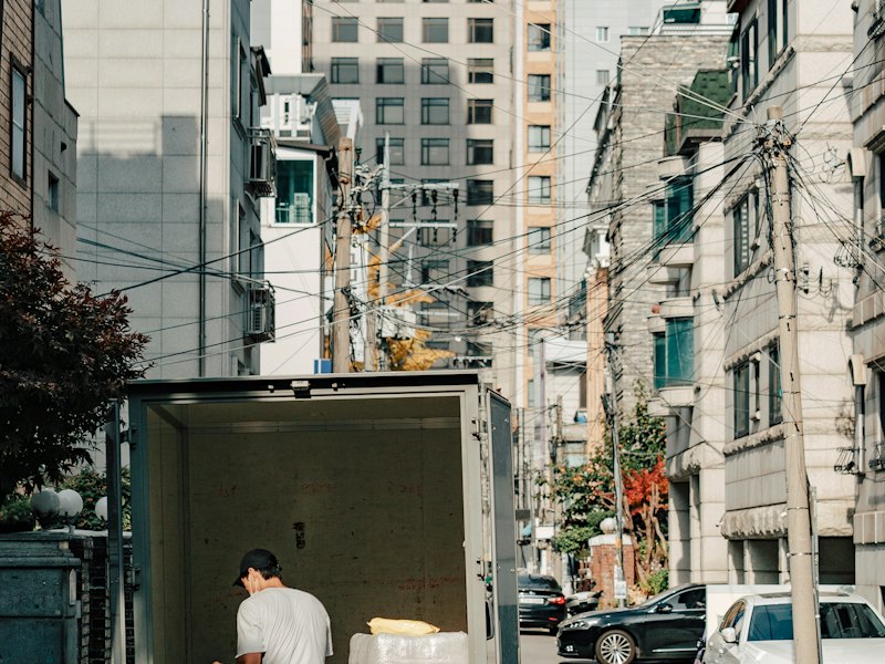 A driver unloading boxes from the back of a lorry
